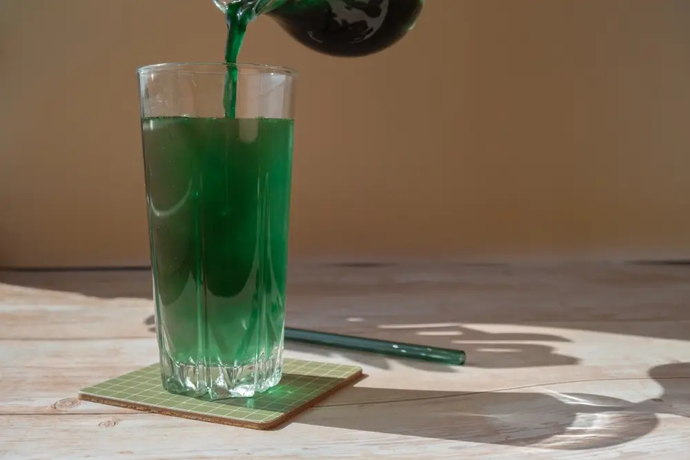 L'algue bleu-vert organique spiruline detox boisson dans de la poudre de verre.